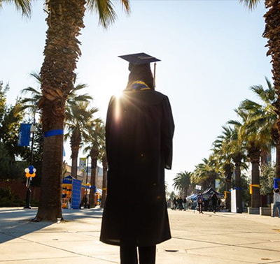 Graduate walking down the Paseo