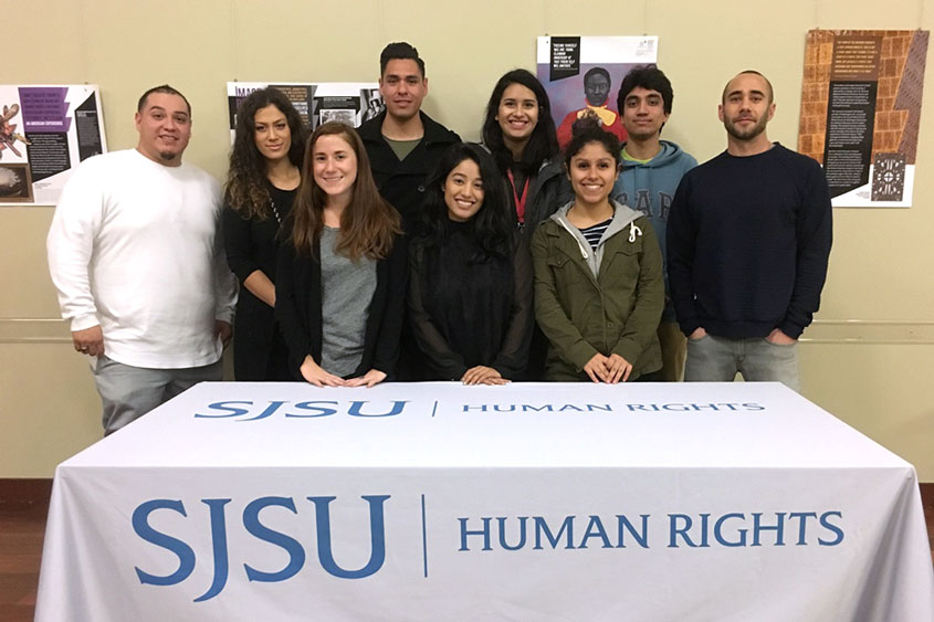 Director W. Armaline and student team behind a booth.