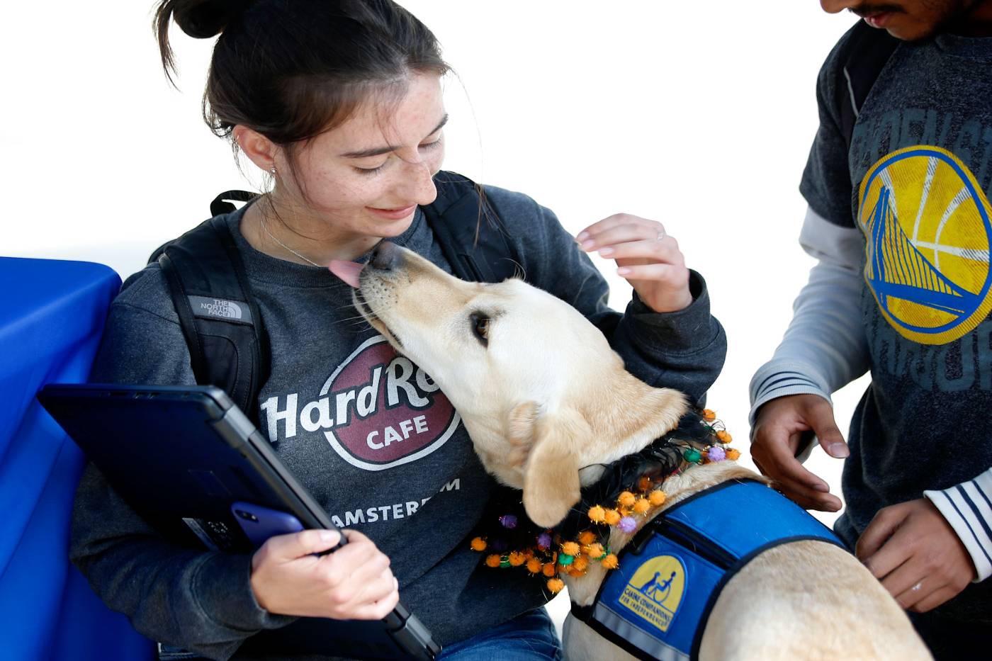 student with laptop and medium size dog