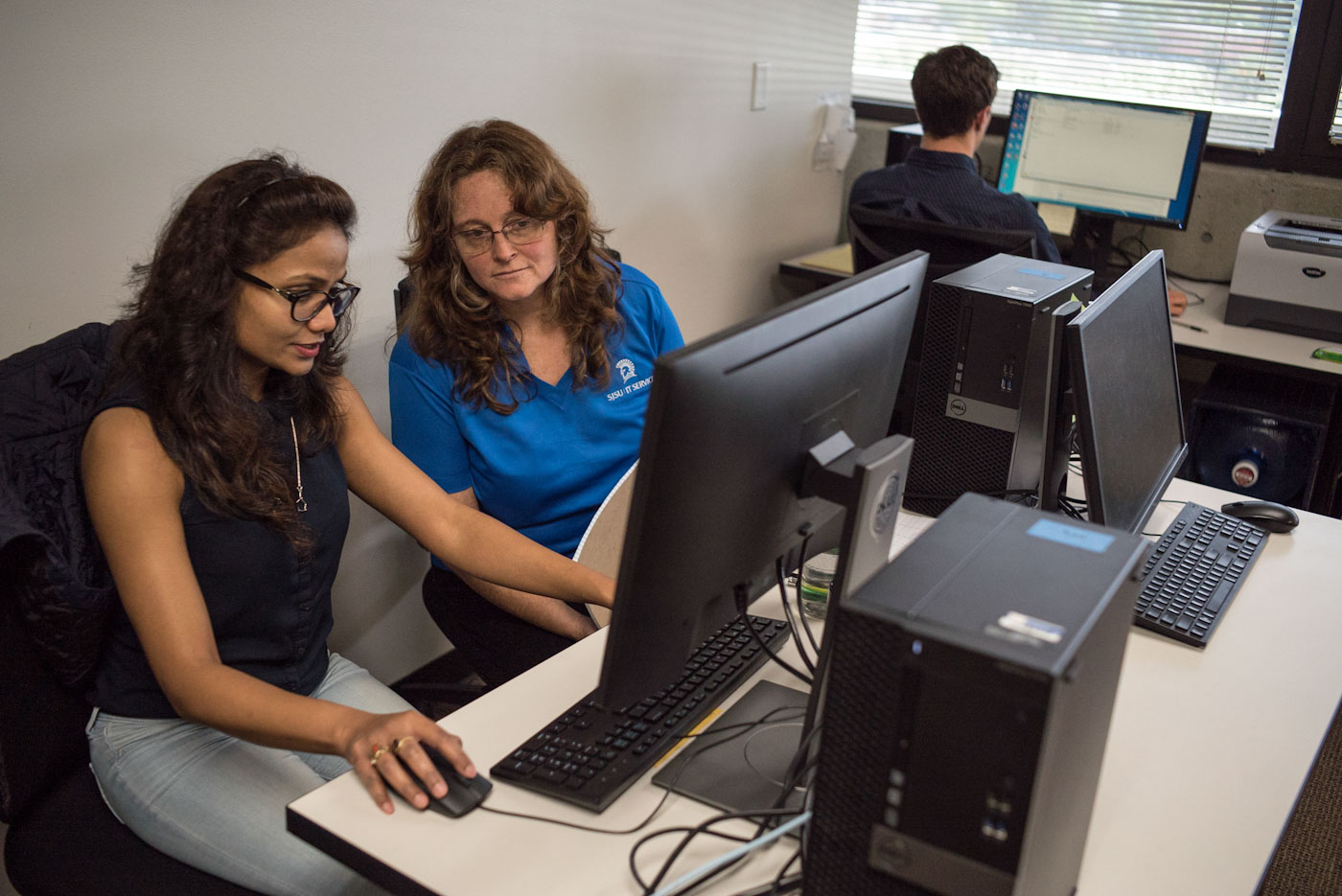 student and sjsu employee sitting at a computer