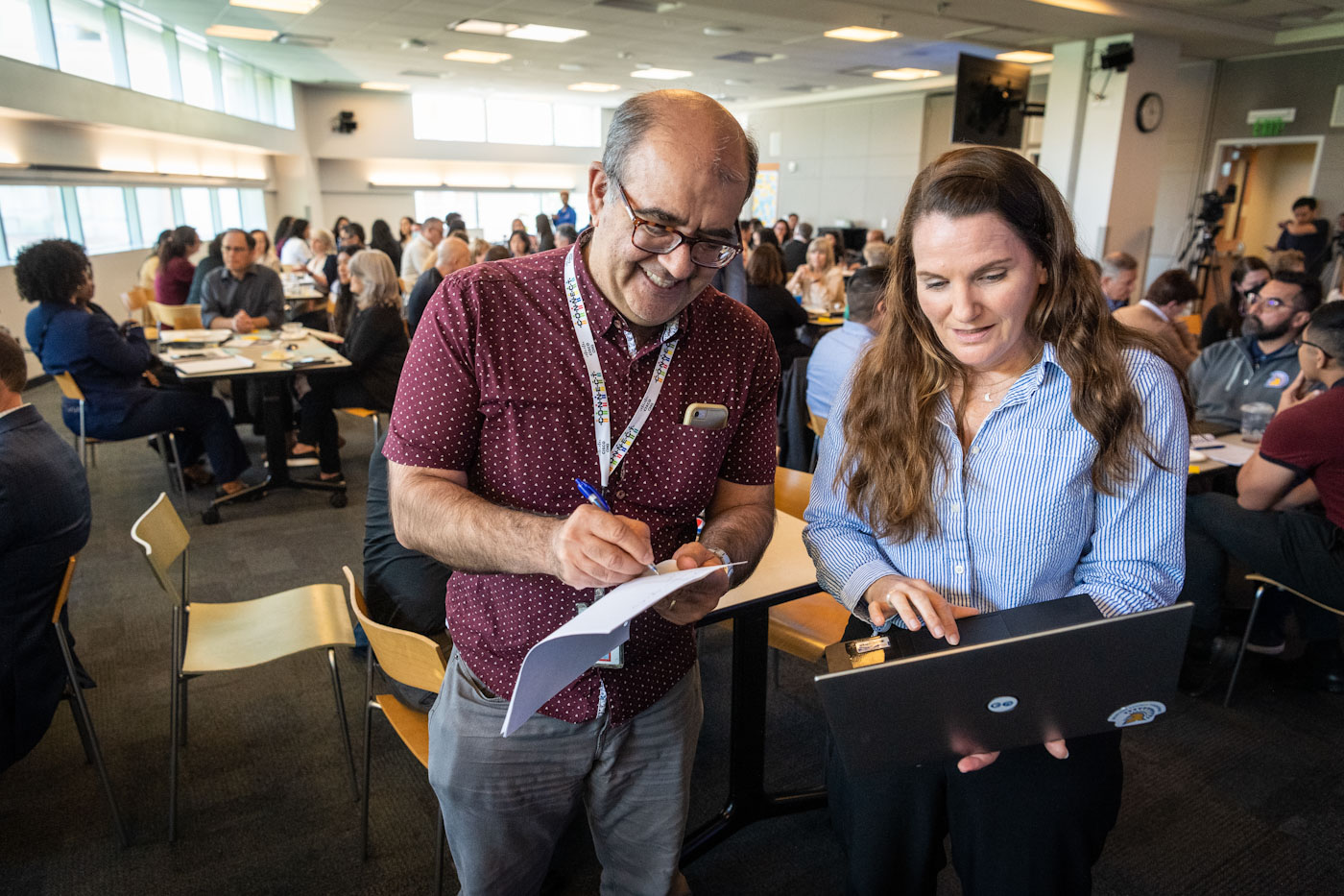 two people who attended a gathering looking at a laptop