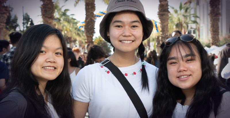 Three newly-admitted students posing for a candid photo