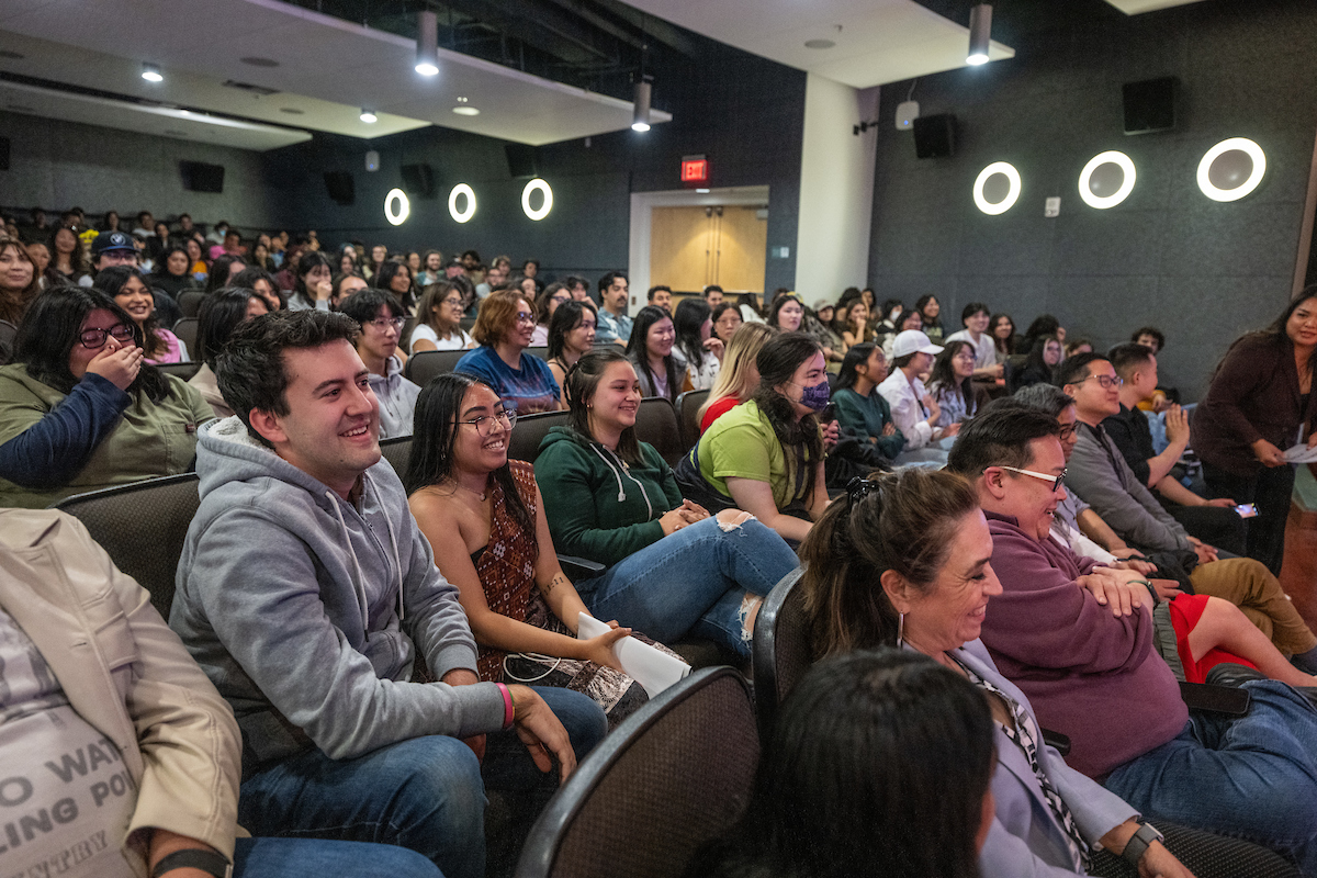 Photo of smiling students in well-lit auditorium