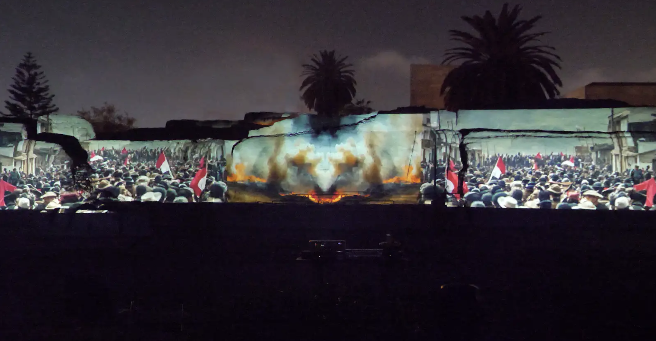 Video Projection displaying many people waving flags alongside images of fire and smoke