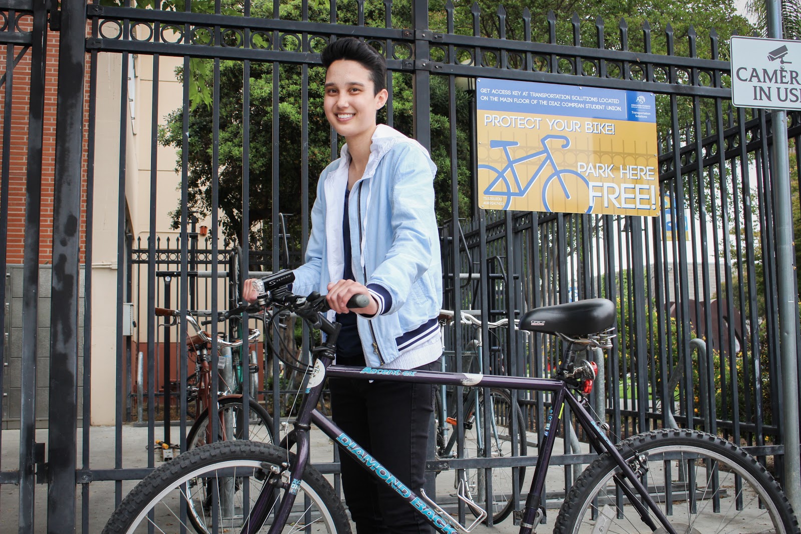 student in front of bike enclosure