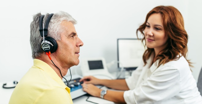 Doctor of Audiology works with a patient wearing headphones.