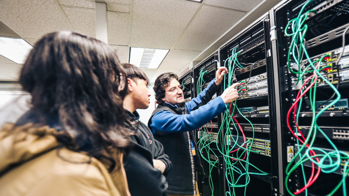 CNSM students working on Cisco router and switches with Dr. Wael Abdeljabbar