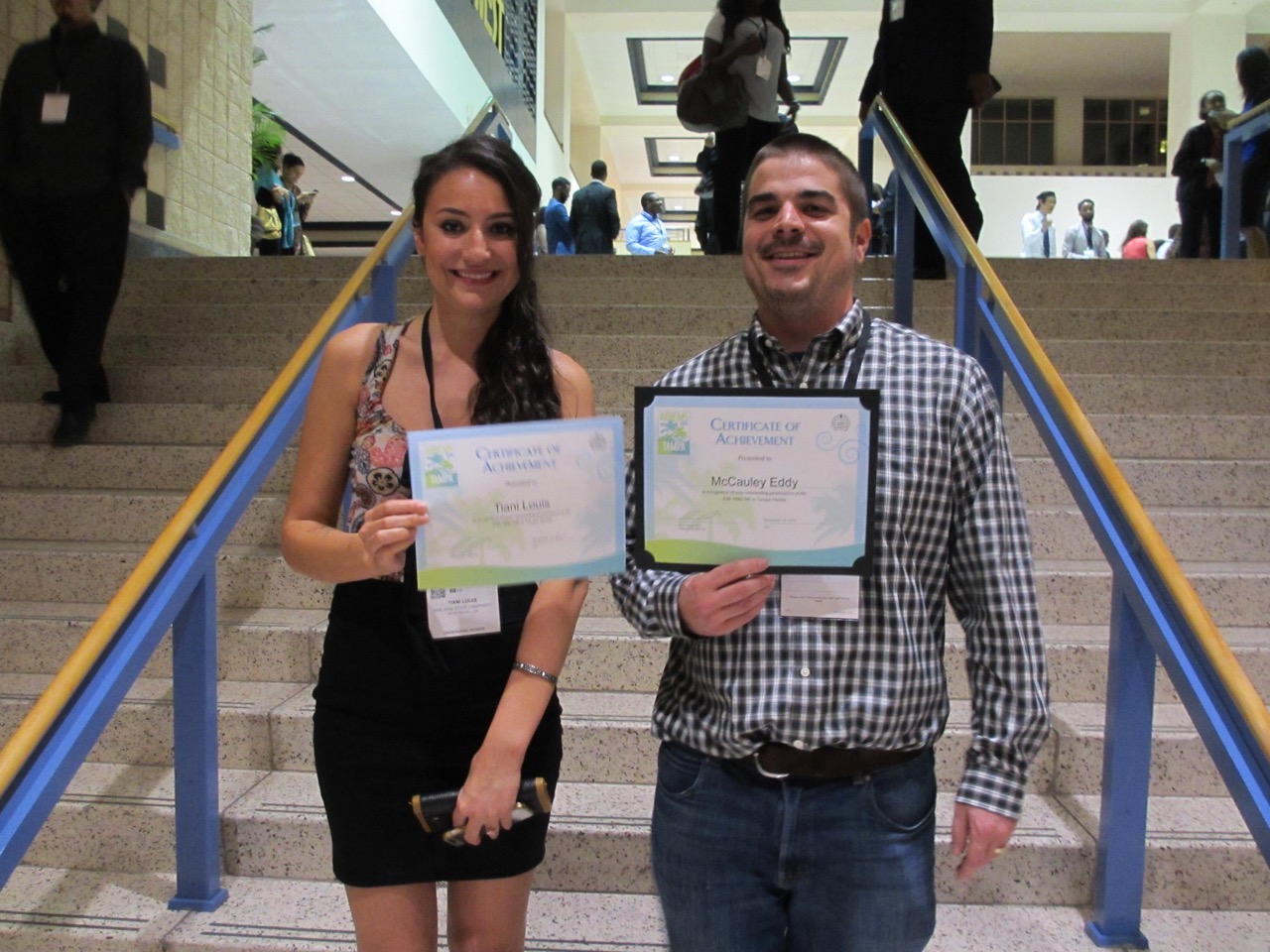 Two students proudly holding Certificates of Acheivement