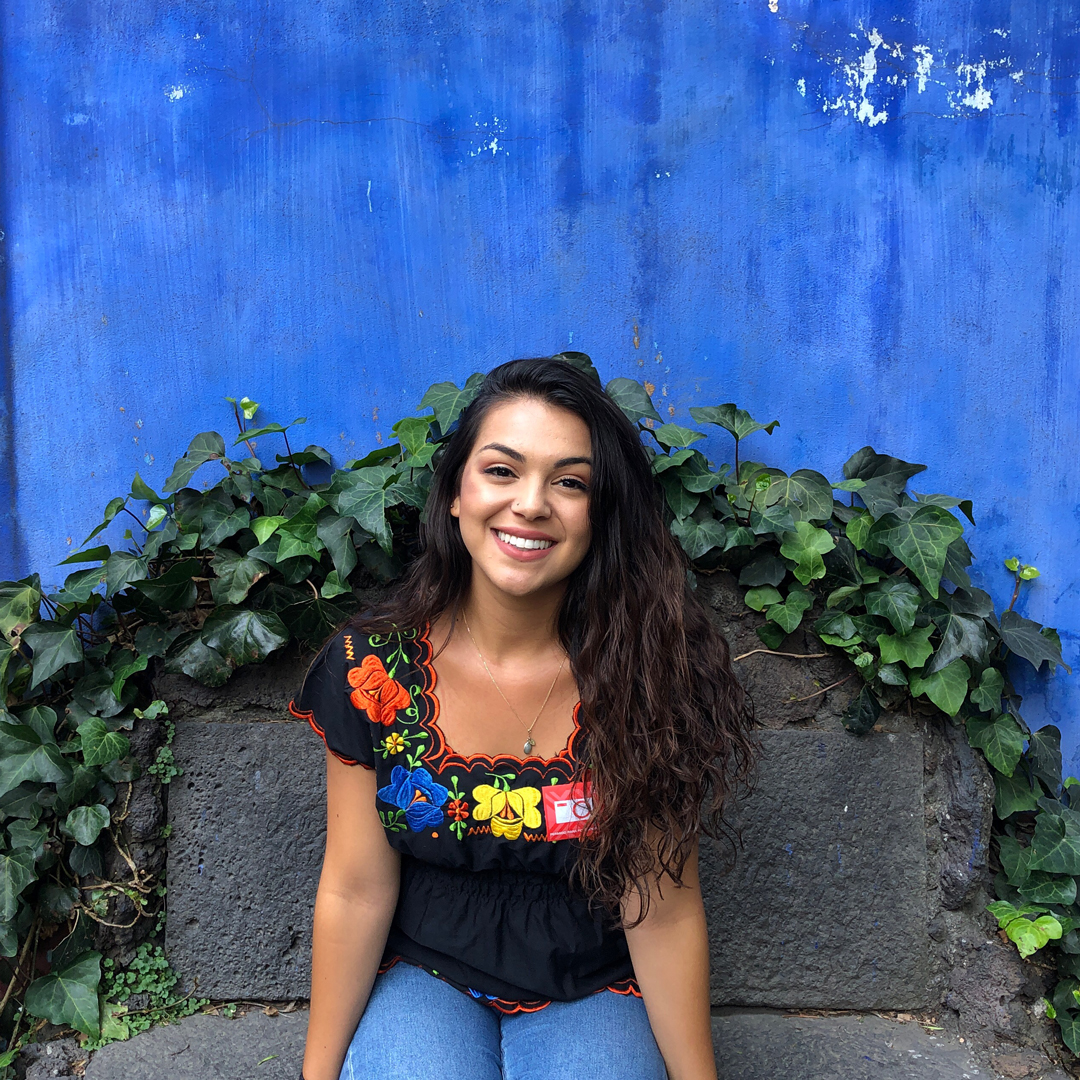 samantha sitting on a bench with a flower shirt and smiling