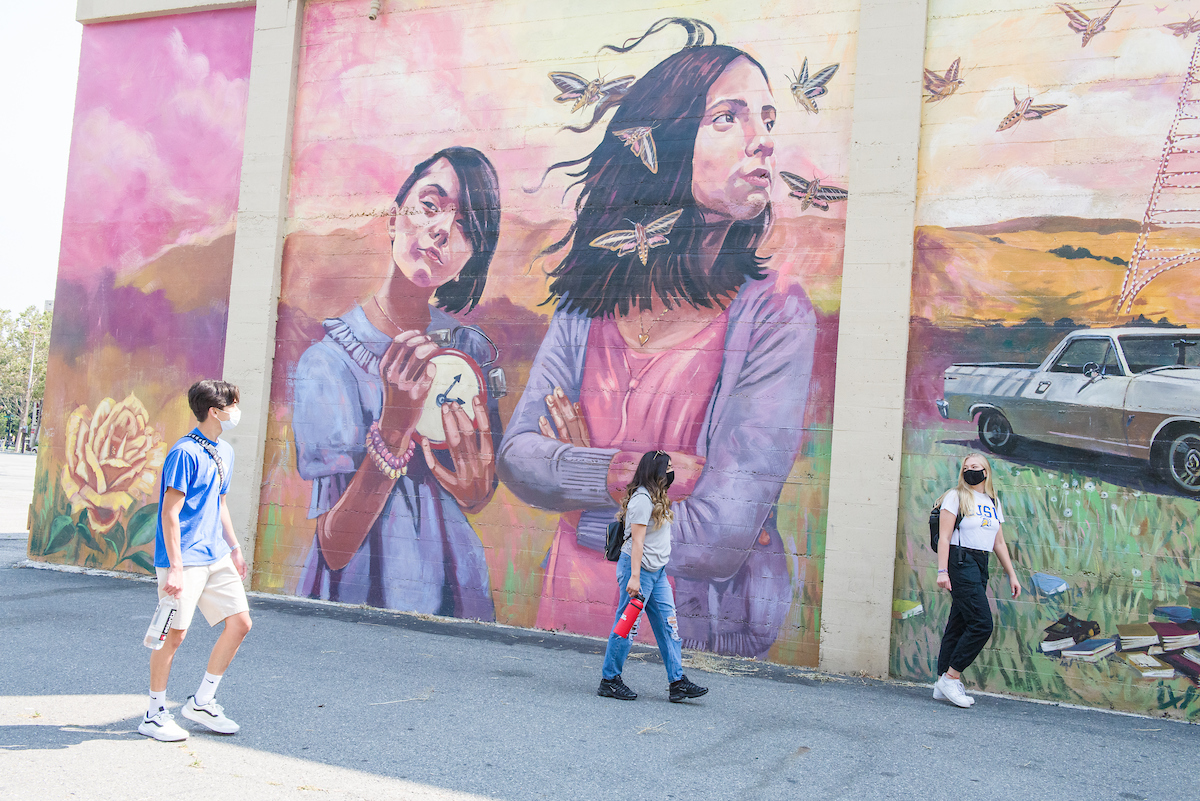 students in front of mural