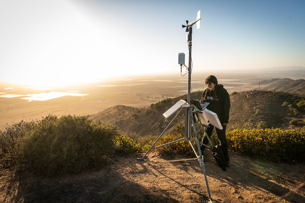 student with meterology machine at sunrise