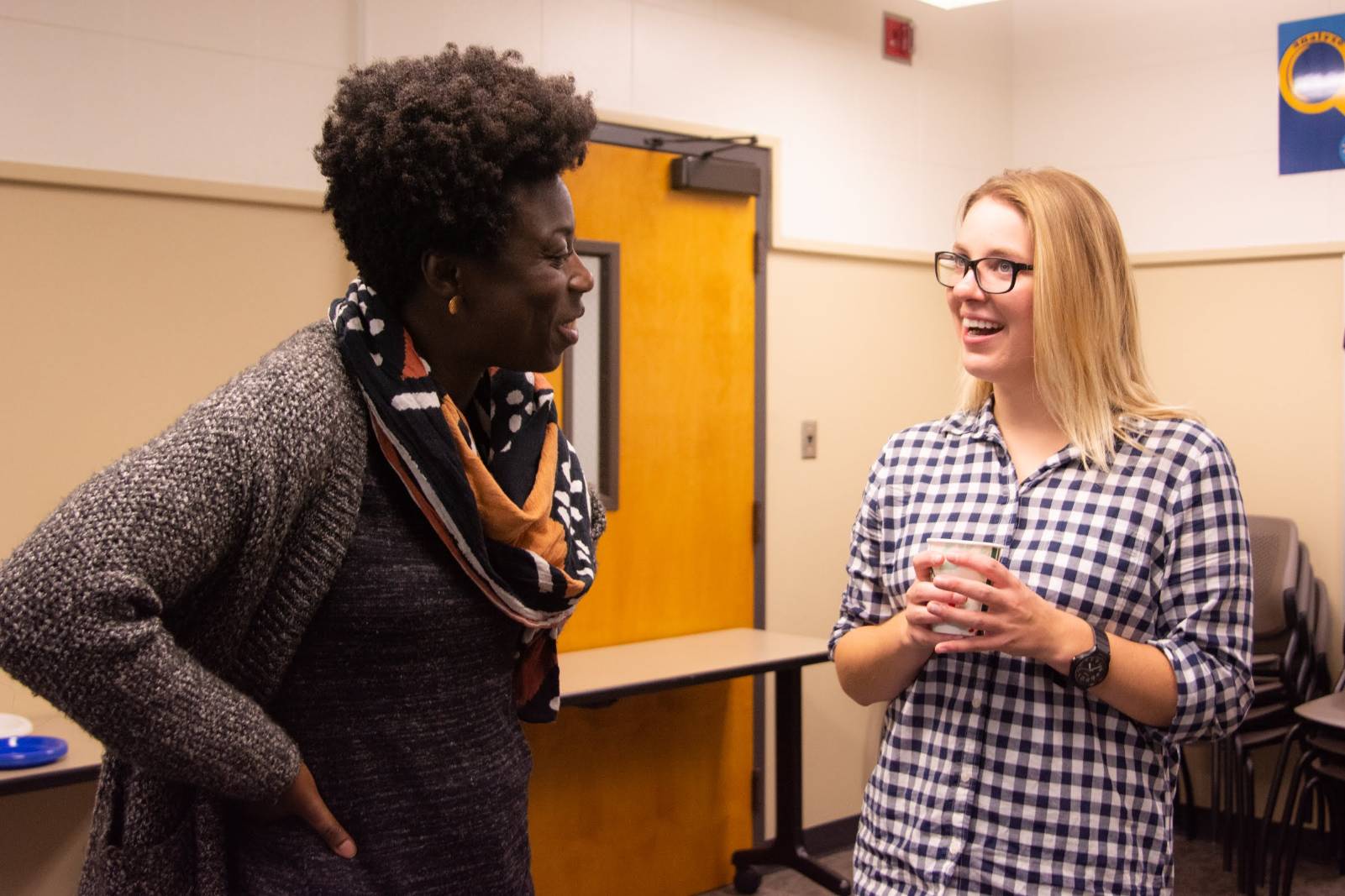 A picture of a professor actively listening as a student speaks.