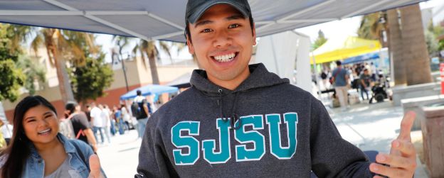 SJSU students at an event on the Paseo smiling at the camera