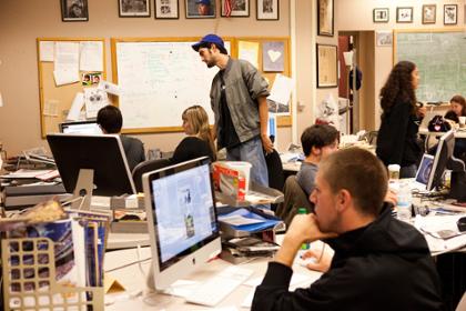 Students work on computers in a newsroom