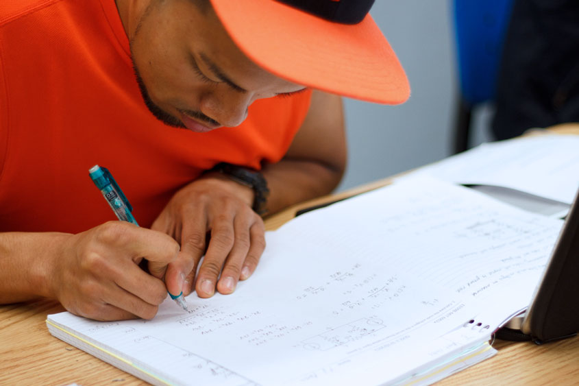 Student writing in his notebook.