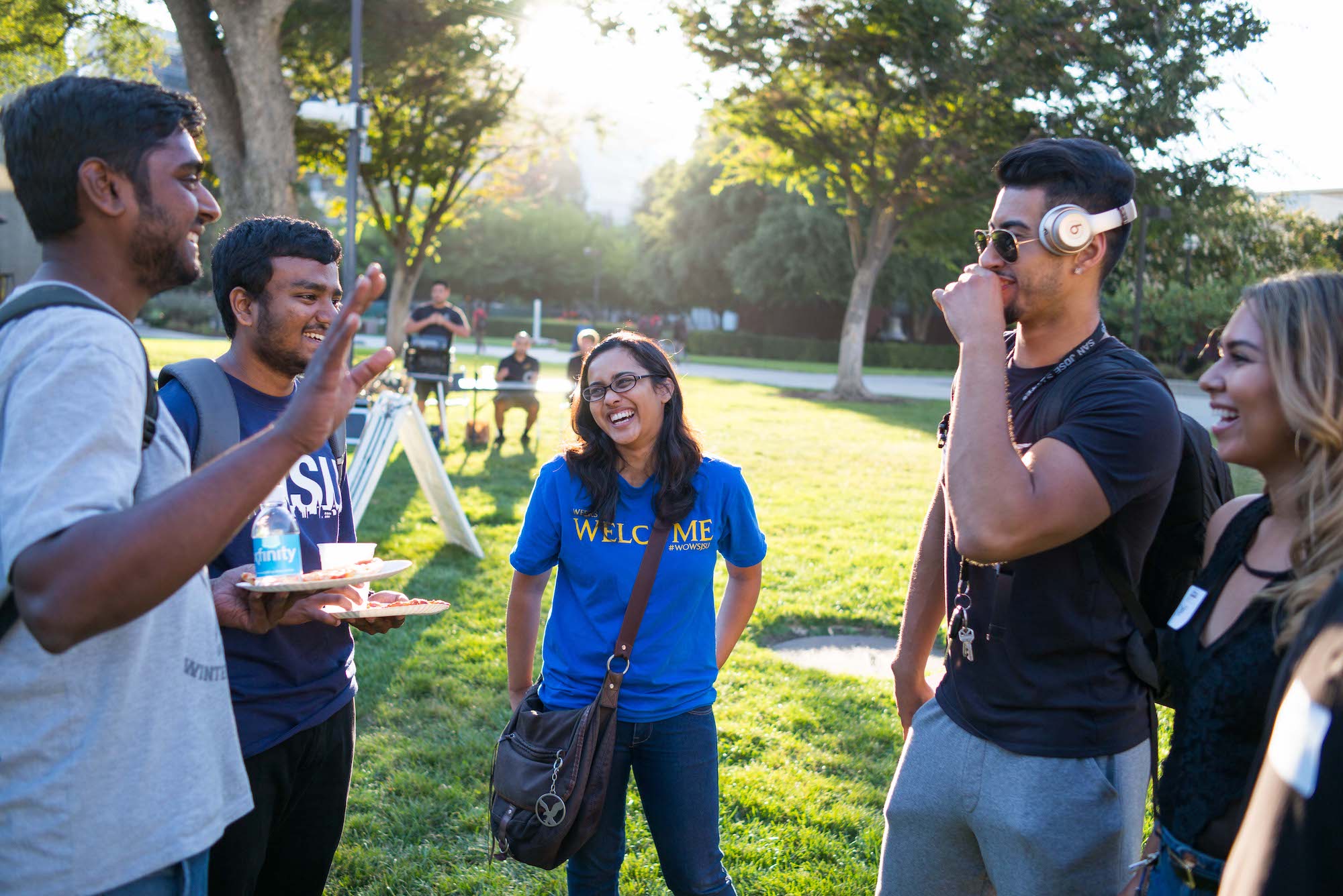 a group of students laughing with eachother in the quad.