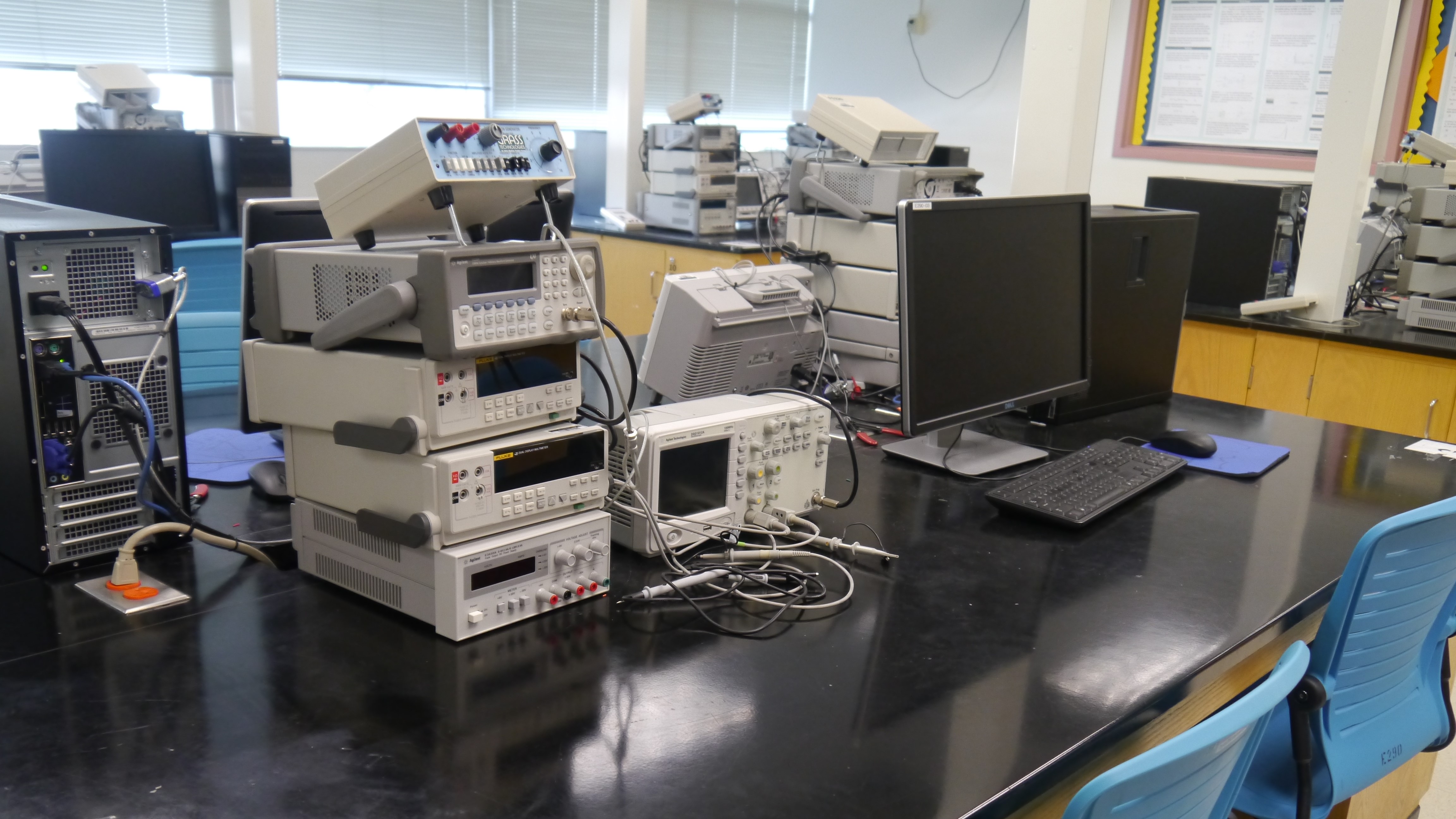 A stack of many different electronic machines on a black desktop.