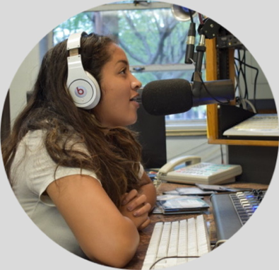 Student speaking to a microphone in a radio studio