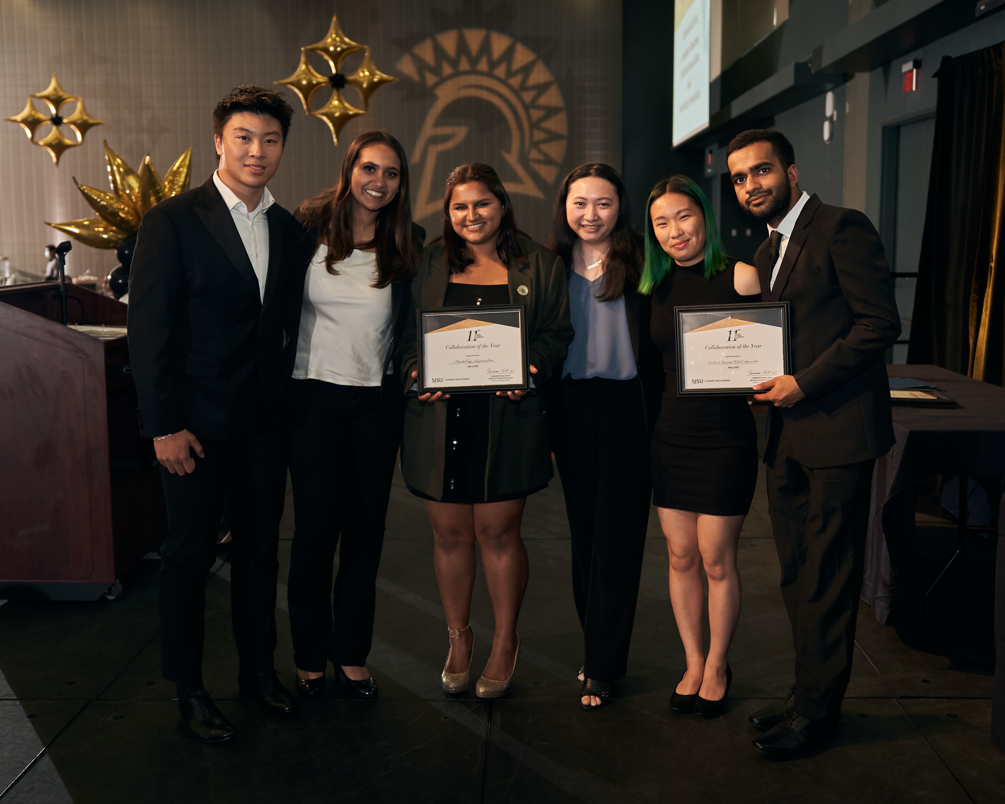 Students displaying award in front of backdrop at 2024 Leadership Gala