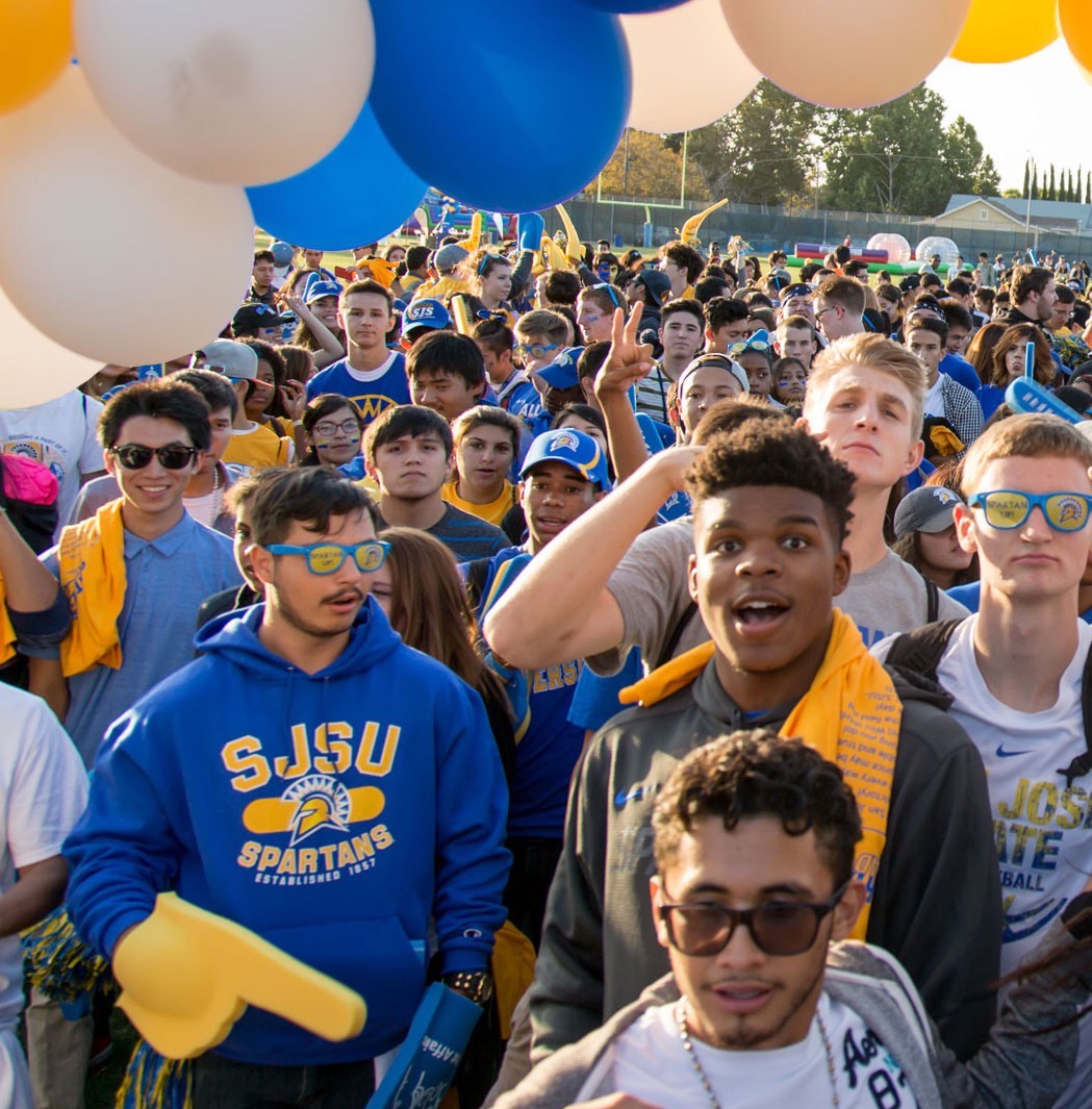 Students and staff hold Spartan Supporting Spartans pennant banners.