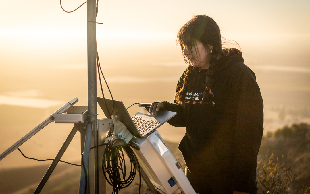 A student working on setting up equipment high in the mountains.