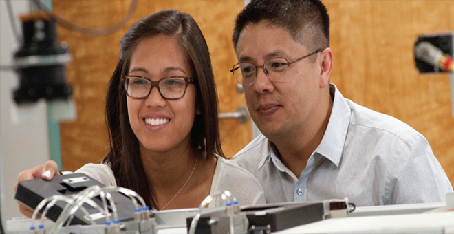 A student works with a professor in a lab