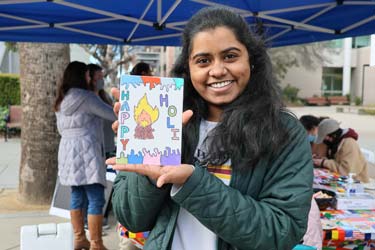 Three students creating art at the ISSS Diwali event during Global Spartan Month