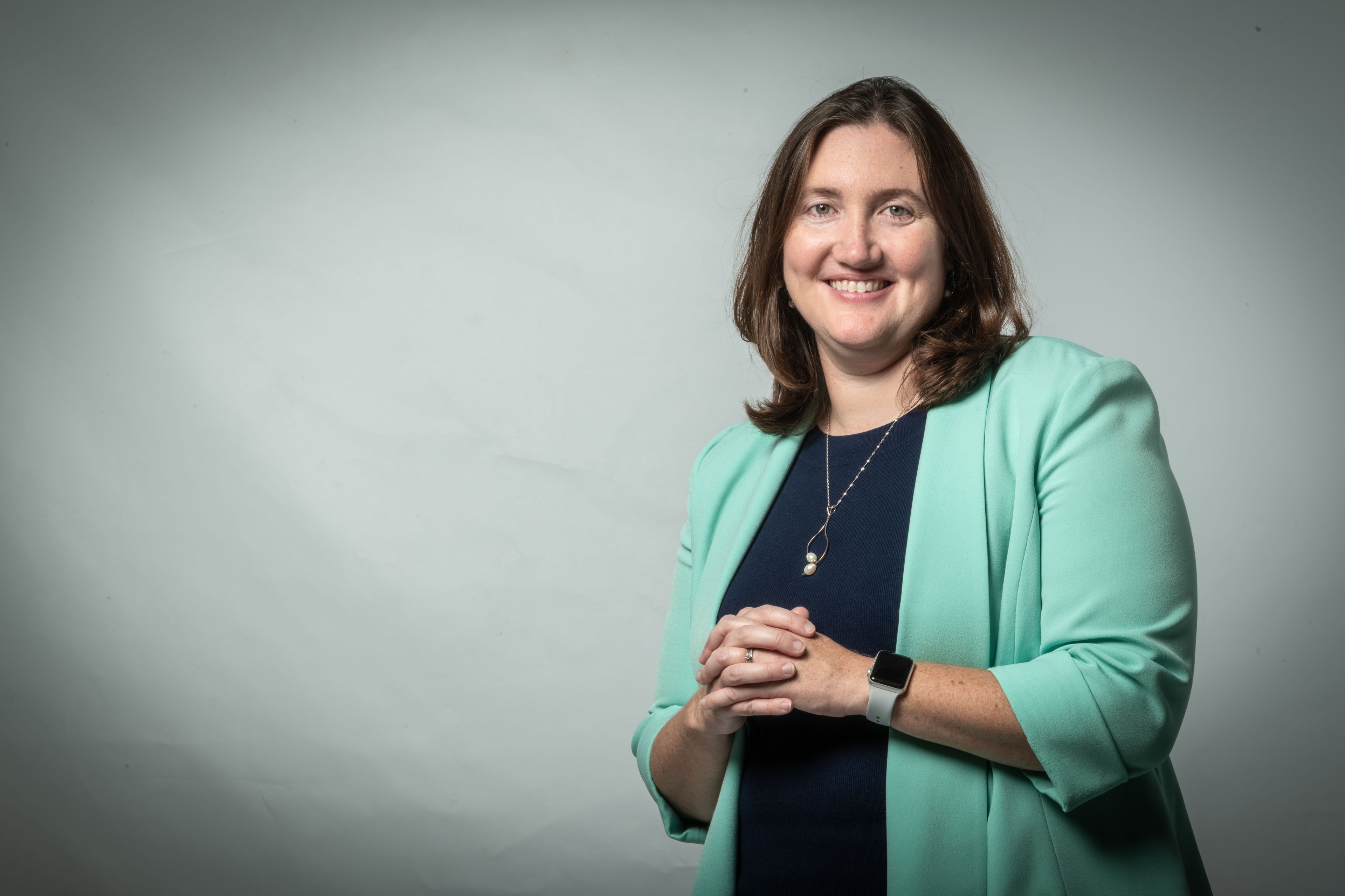 portrait of Katie Wilkinson, professor of biological sciences, wearing green jacket in studio. patents, biology, SJSU College of Science,  neuropathy, innovation