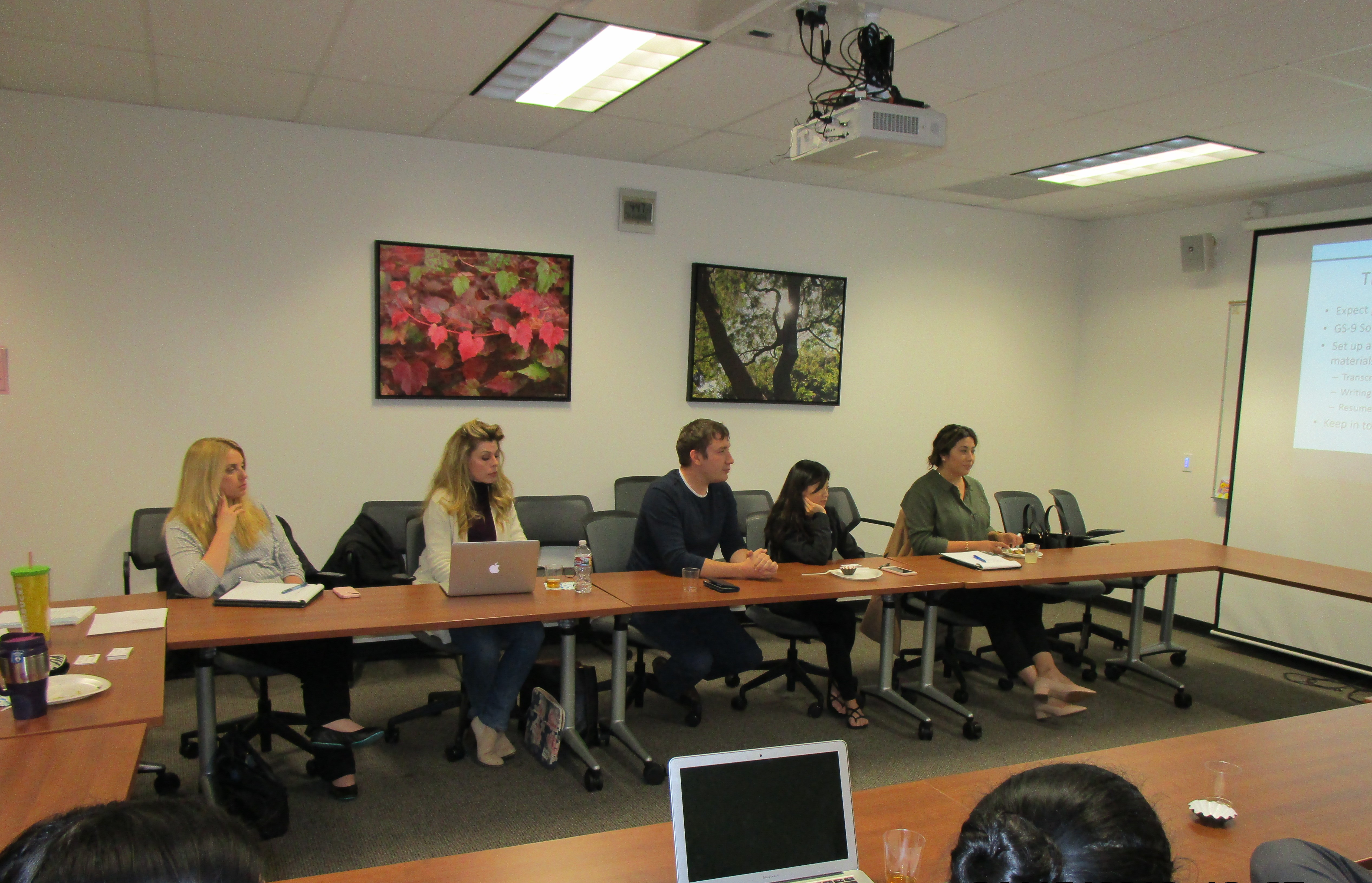 Many students sitting formally dressed in a classroom observing a lecture.