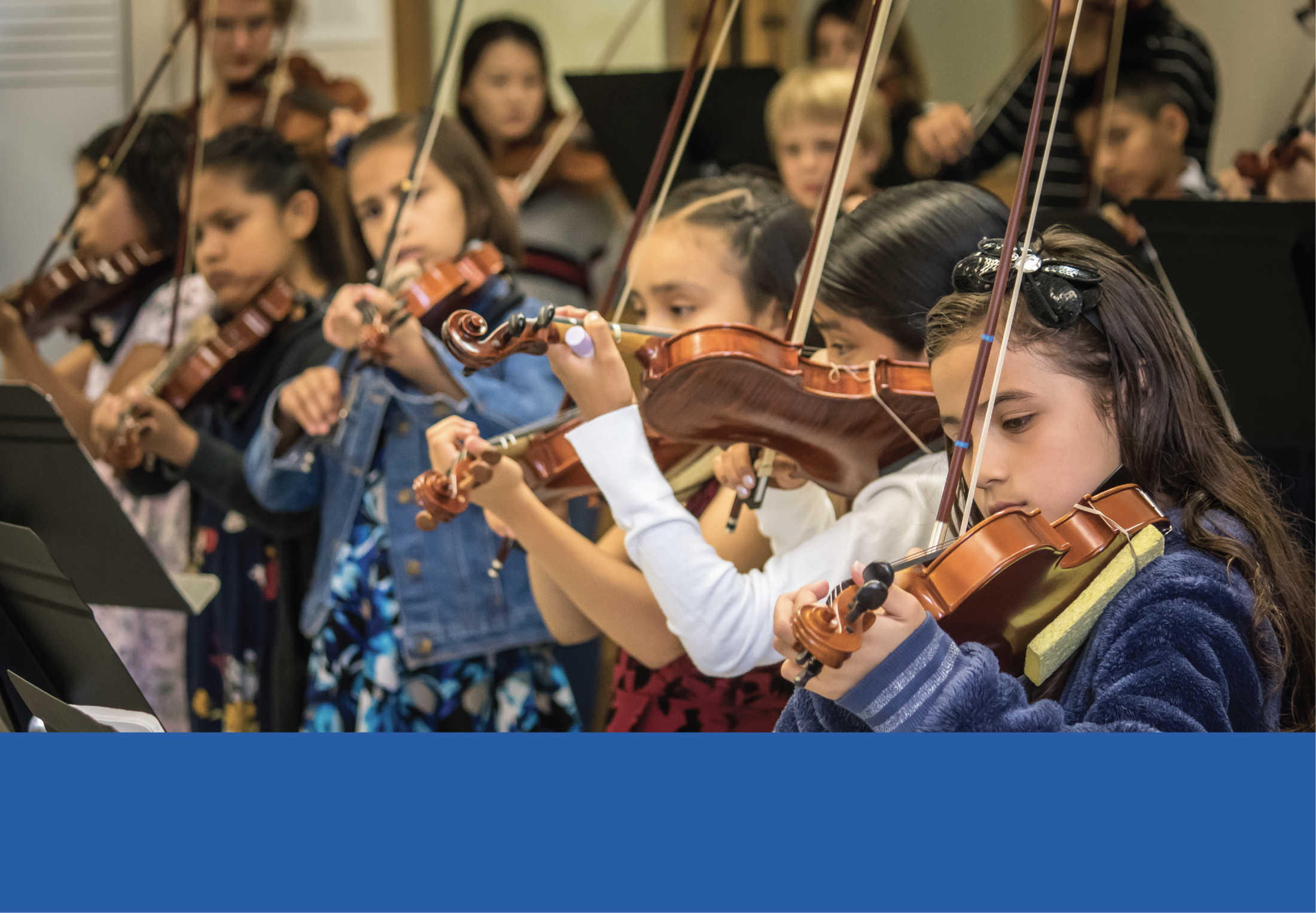 Young students playing violins.