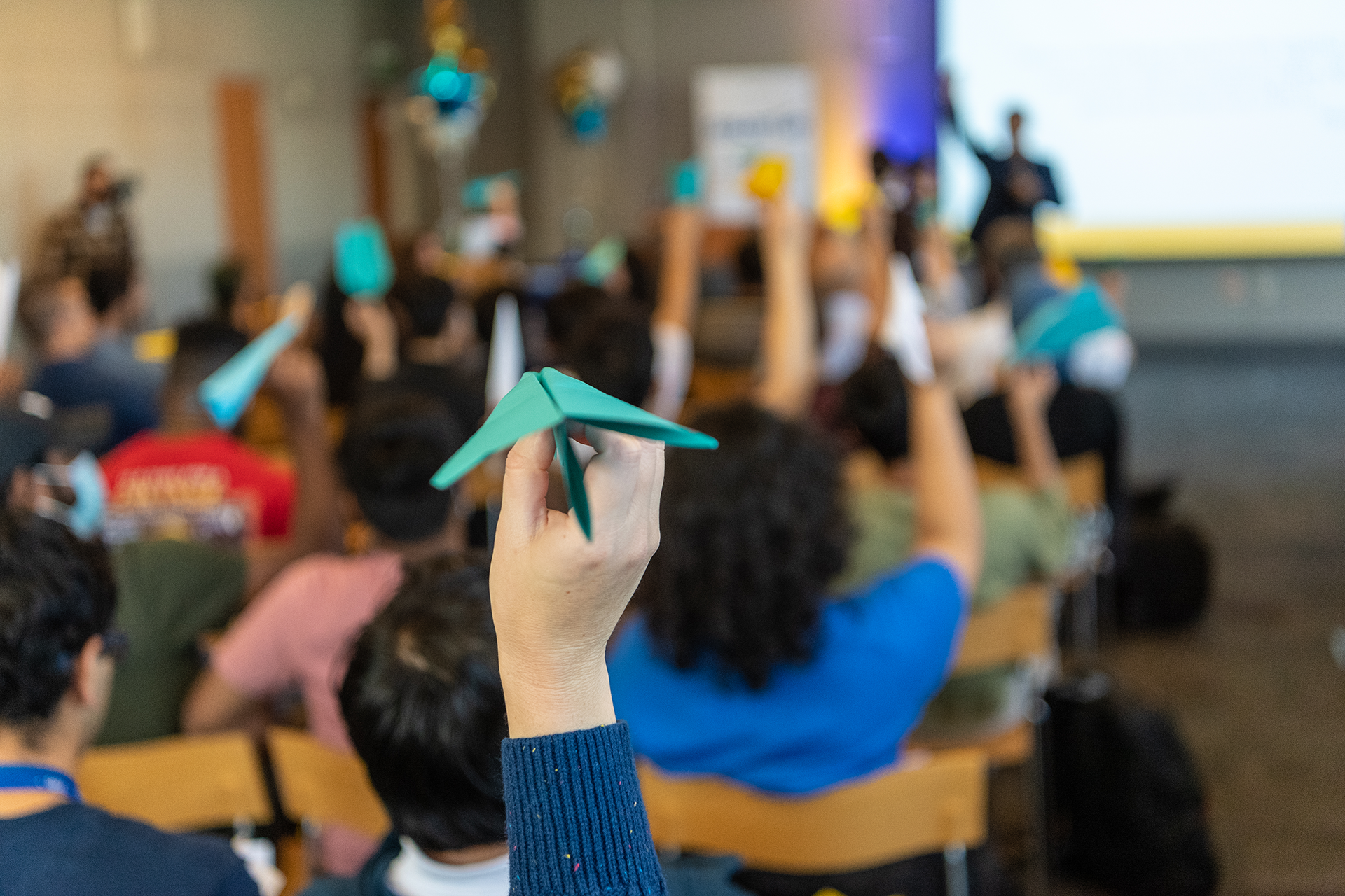 Students holding up paper airplanes