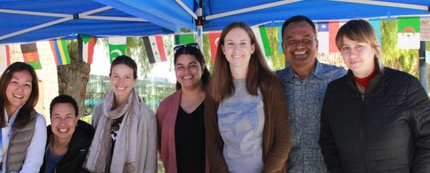 People at a tabling event smiling at the camera