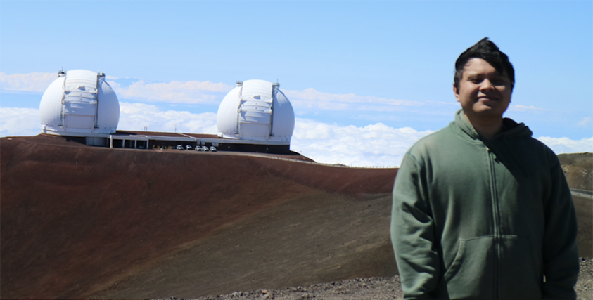 Photograph of Enrique Cabrera on Moana Kea with the Keck telescope in the background.