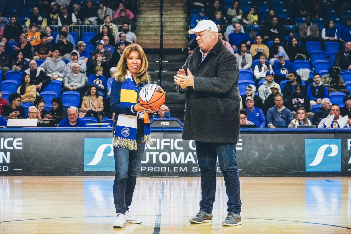 The president holding a basketball and standing next to Jeff Konya.