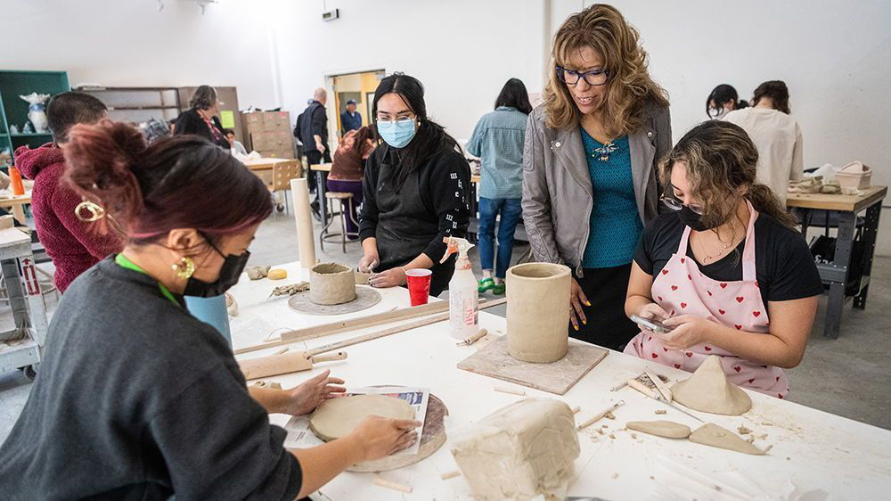 The president look at student art.