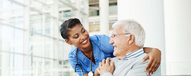 A nurse converses with an elderly man