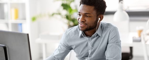 A person in an office setting smiles at the camera