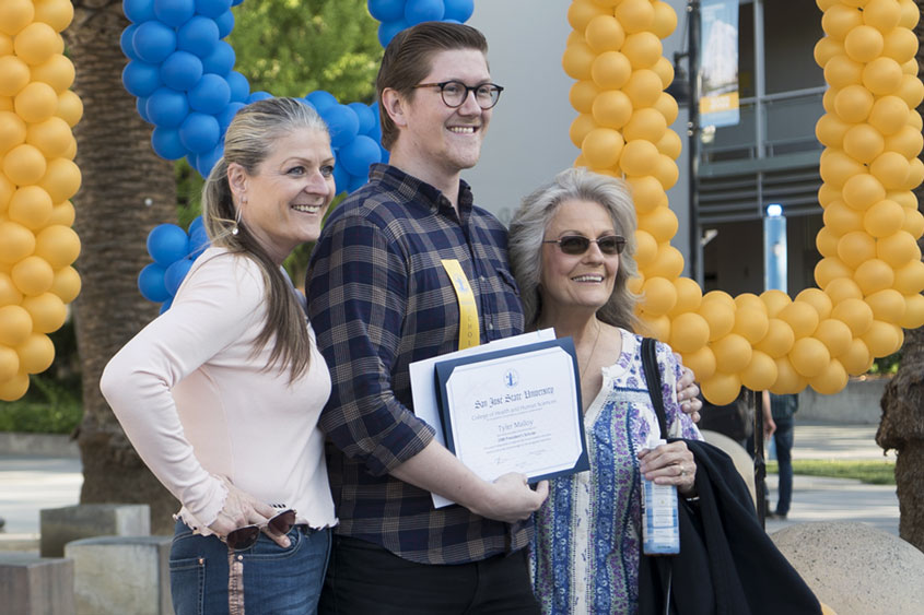 Student holding his award and posing with family.