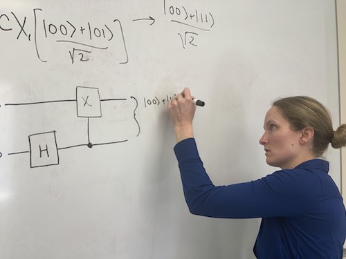 Dr. Hurst writing entangled states on whiteboard