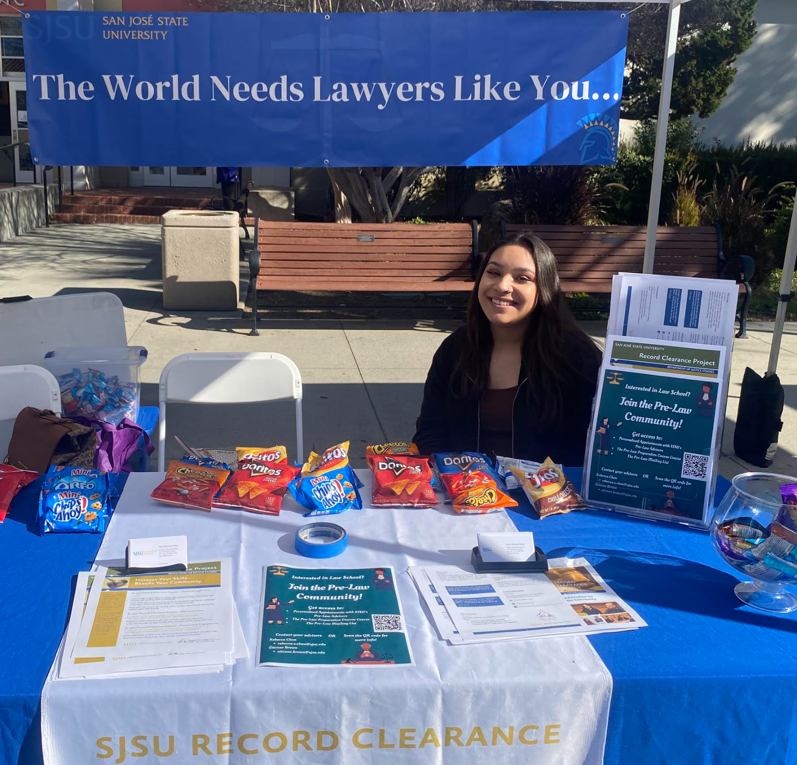 Young woman in twenties tabling for speaker series. 