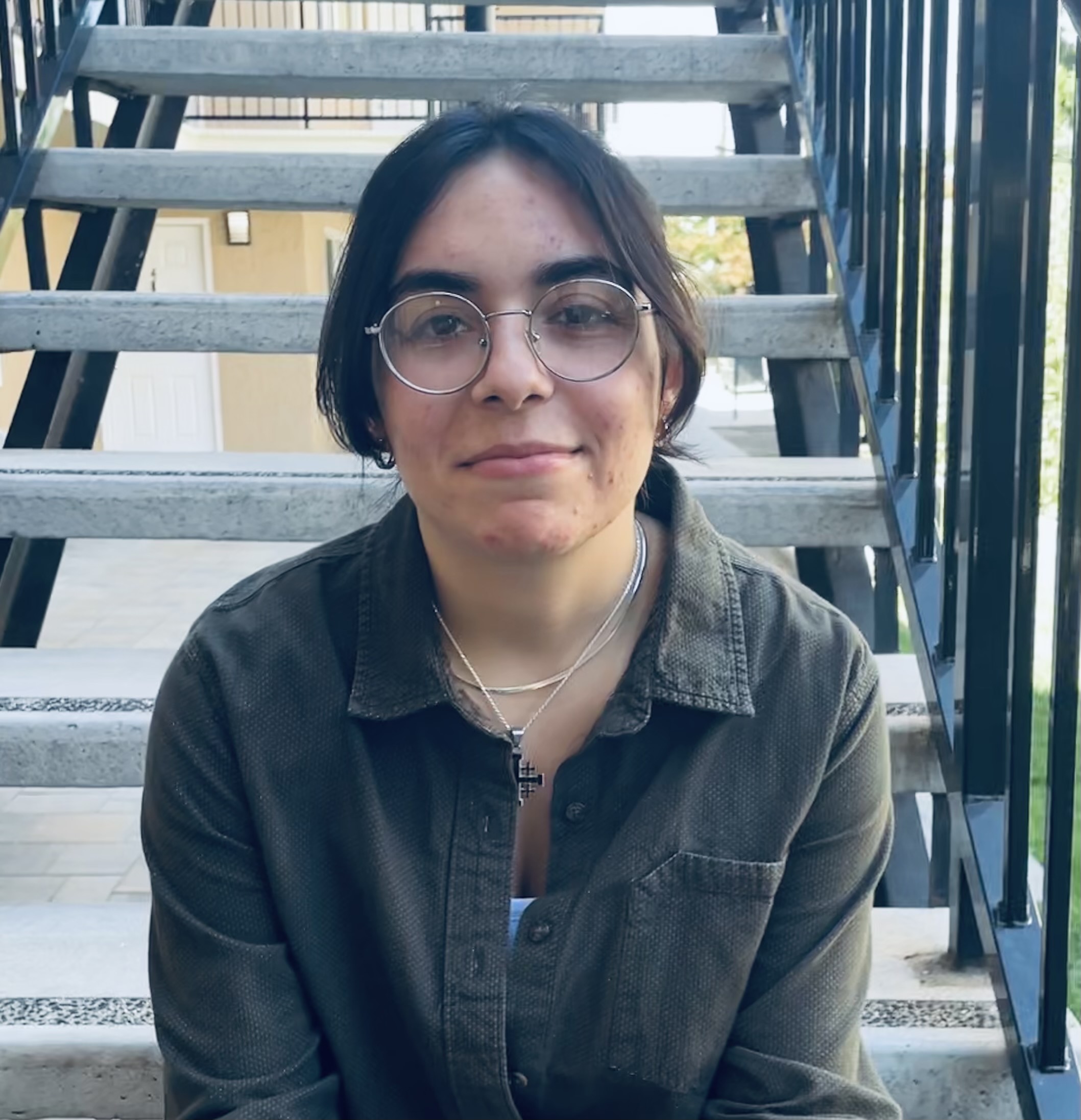 Young woman with glasses sitting on the stairs