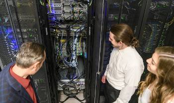 people look at an electrical cabinet with many wires coming out