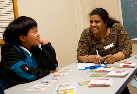 person sits at low table with child in study