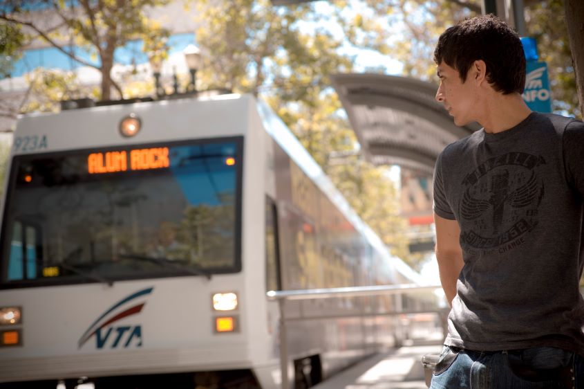 Young individual watching the VTA lightrail arrive.