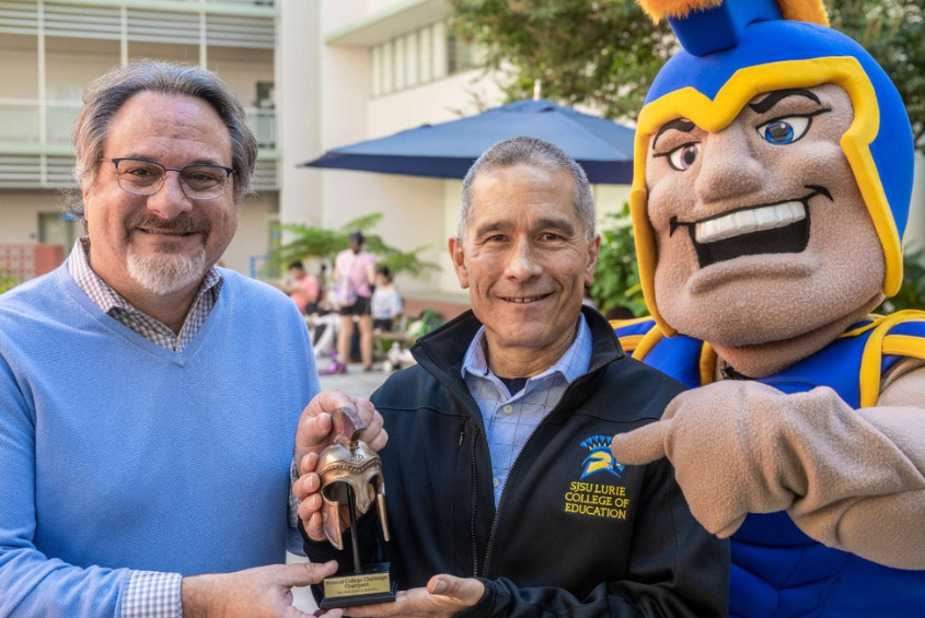 Provost Vincent Del Casino, Jr. presents interim dean David Whitenack of the Connie L. Lurie College of Education with the Provost Challenge trophy for 2025.