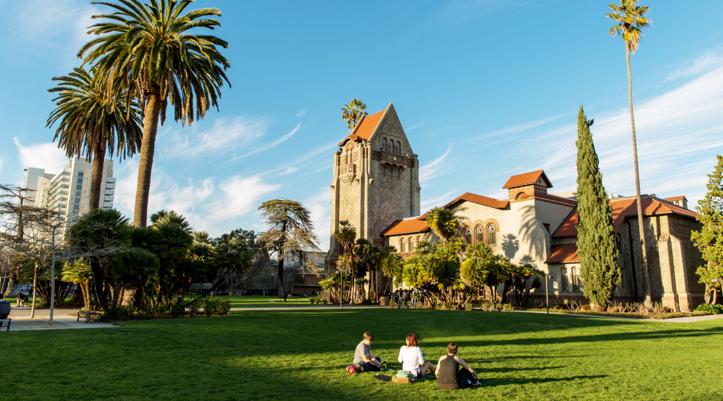 Students sitting on grass outside Tower Hall.