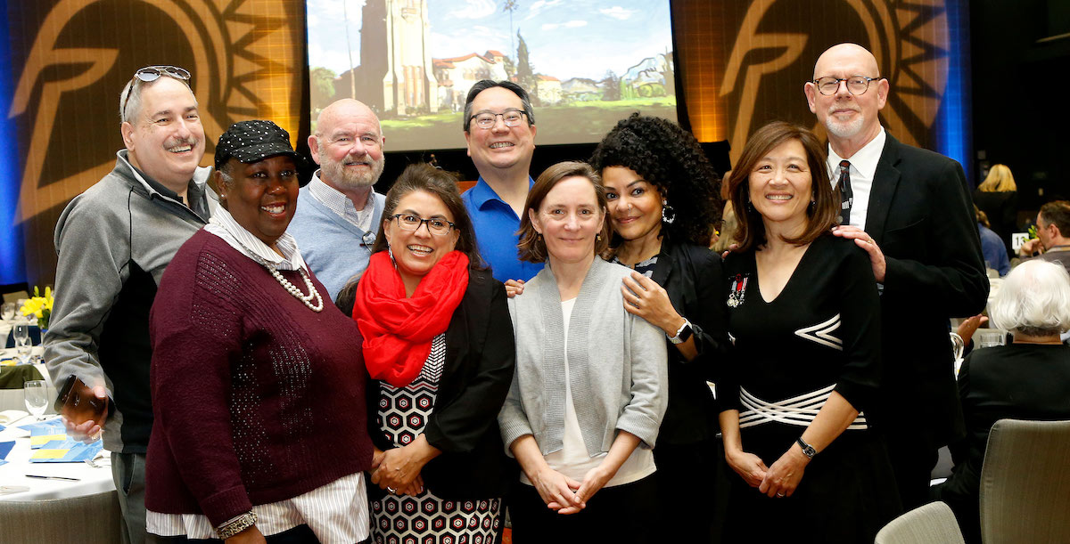 Faculty and staff hudling together for a group shot.