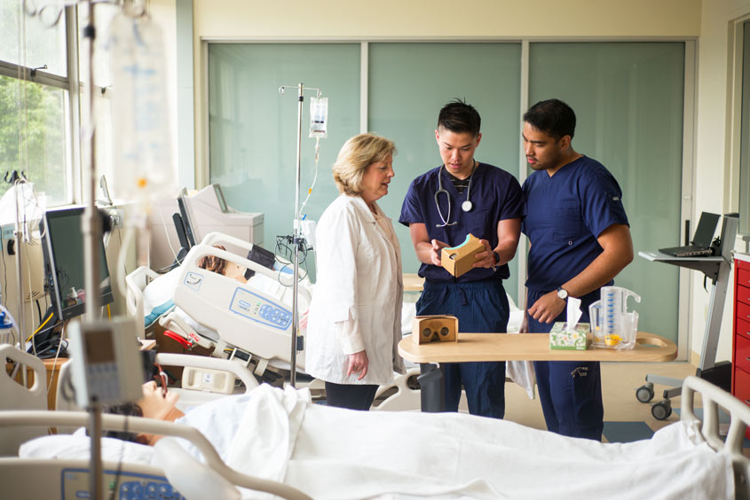 Two nursing students discuss the VR headset with their director.