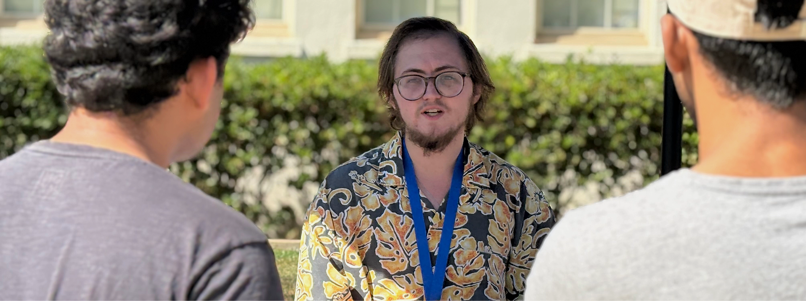 Tutor wearing lanyard talking to students outside