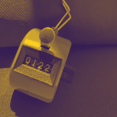 Orange clicker counter on a blue tablecloth background 